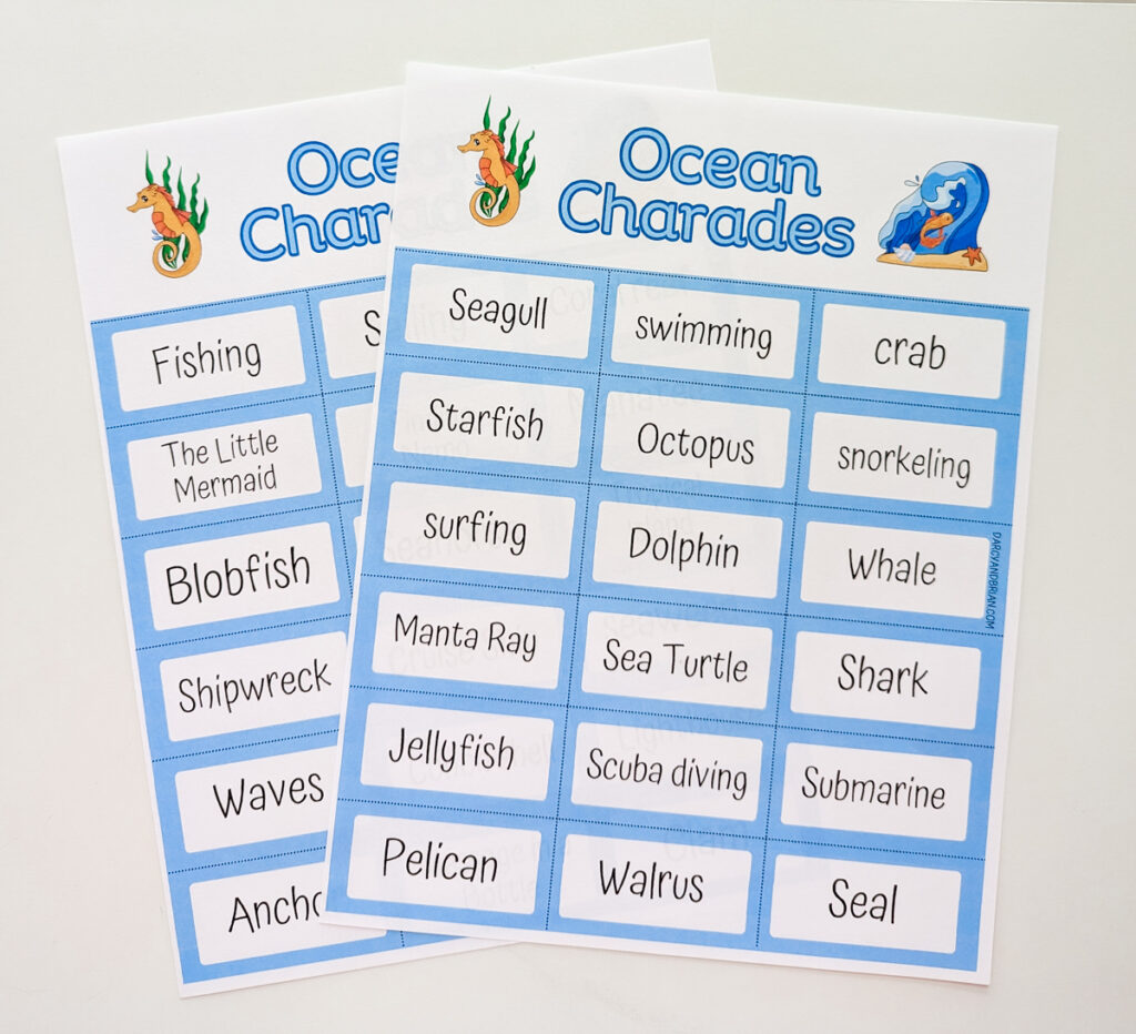 Both pages of Ocean Charades printed out on paper and laying on white table. Pages are overlapping each other.