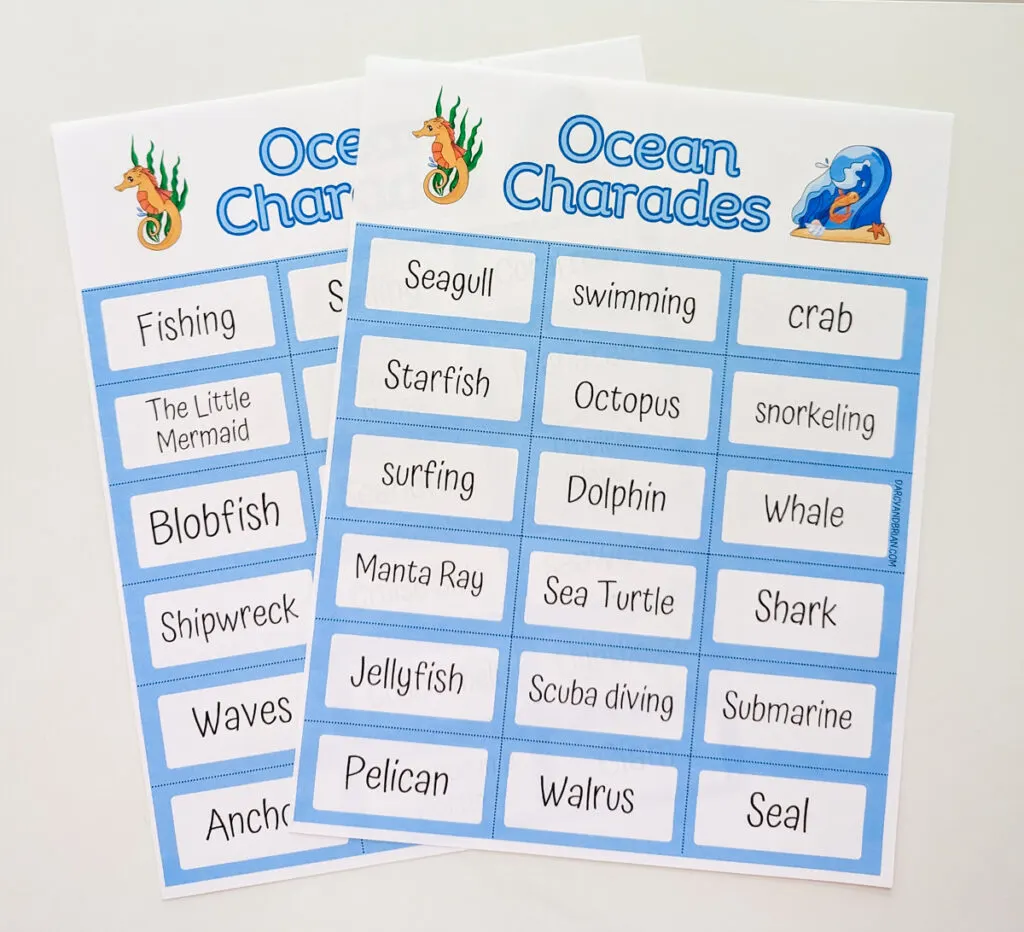 Both pages of Ocean Charades printed out on paper and laying on white table. Pages are overlapping each other.