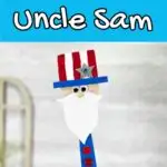 White text on blue background at the top says Wooden Spatula Uncle Sam. Close up view of finished project made using a flat bamboo spatula, craft foam, and paint.