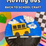 Dark blue text box at the top with white text says Moving Bus Back to School Craft. Photo beneath shows a paper bus on a stick inside a slit in a blue and black painted paper plate to look like the bus is driving on the road.