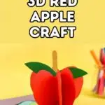 White text with black outline on yellow background says 3D Red Apple Craft. Below text is a picture of an apple craft made out of red paper standing upright with a popsicle stick stem and green leaf. Craft supplies are in the background.