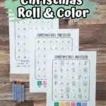 Three different roll and color Christmas printable pages laid out in a diagonal line, overlapping each other. There are crayons and dice nearby. At the top of the photo is white text over a green splash of color. Text says Christmas Roll & Color.