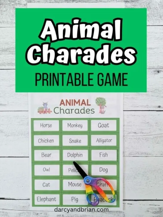 White and black text on a green rectangle at the top says Animal Charades Printable Game. Below is a photo of a sheet of charades cards with animals printed out and a pair of scissors laying on it.