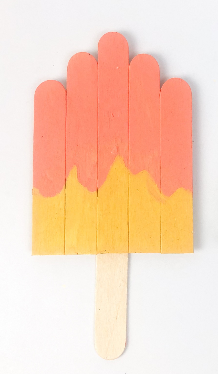 Popsicle sticks glued and cut into a popsicle shape. They are painted yellow and pink.