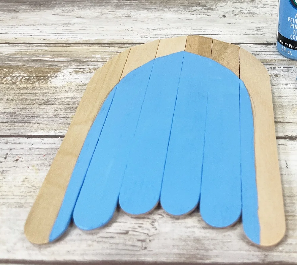 Popsicle sticks painted light blue except the outer section is unpainted.