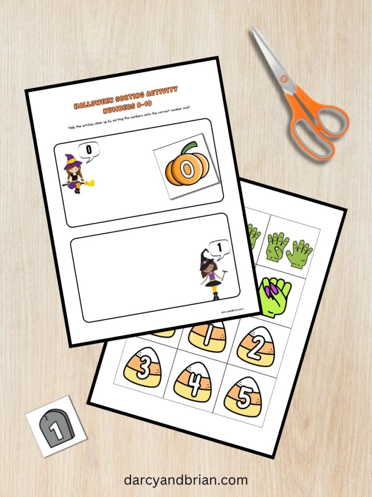 Digital mockup of Halloween themed sorting game. First page with number mats for zero and one are overlapping a page of cards to be cut apart. One card with 0 is on the mat. Another card is off to the side along with a pair of scissors.