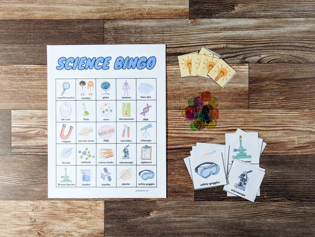Overhead view of one bingo card with science theme. Calling cards and bingo chips are to the right.