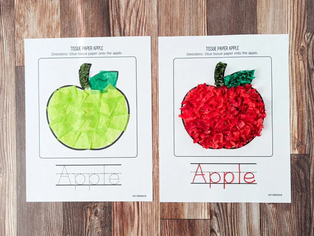 Finished apple crafts made with tissue paper and a printable template. The papers lay side by side on a table.