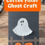 Completed coffee filter ghost craft on construction paper.