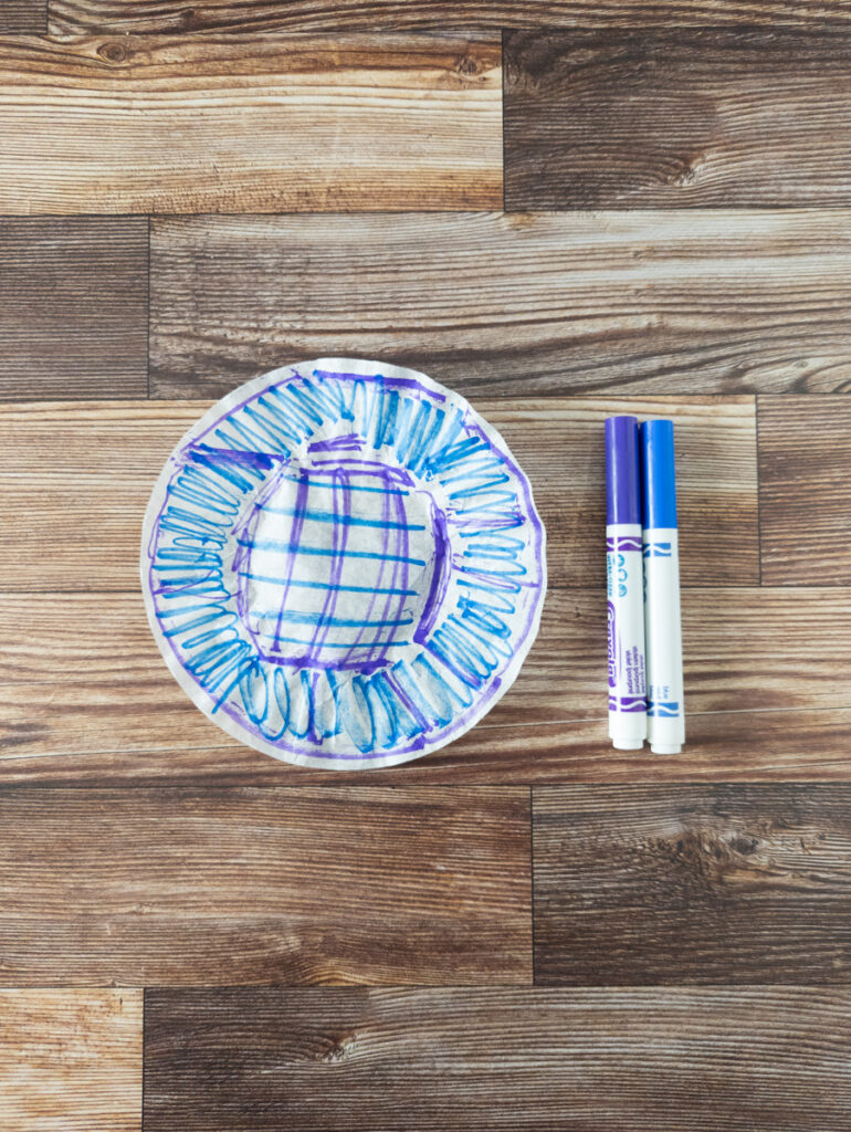 Coffee filter colored with blue and purple markers.