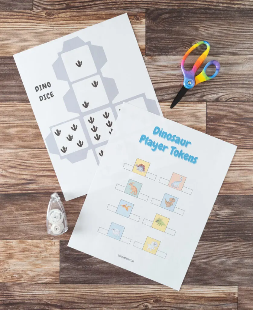 Custom dino paper six sided die and sheet of baby dinosaur player pieces to cut out and use as pawns around the board.