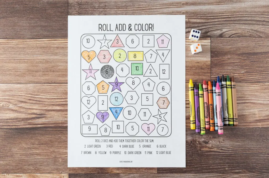 Worksheet for rolling, adding, and coloring printed out with some shapes colored in with crayons.