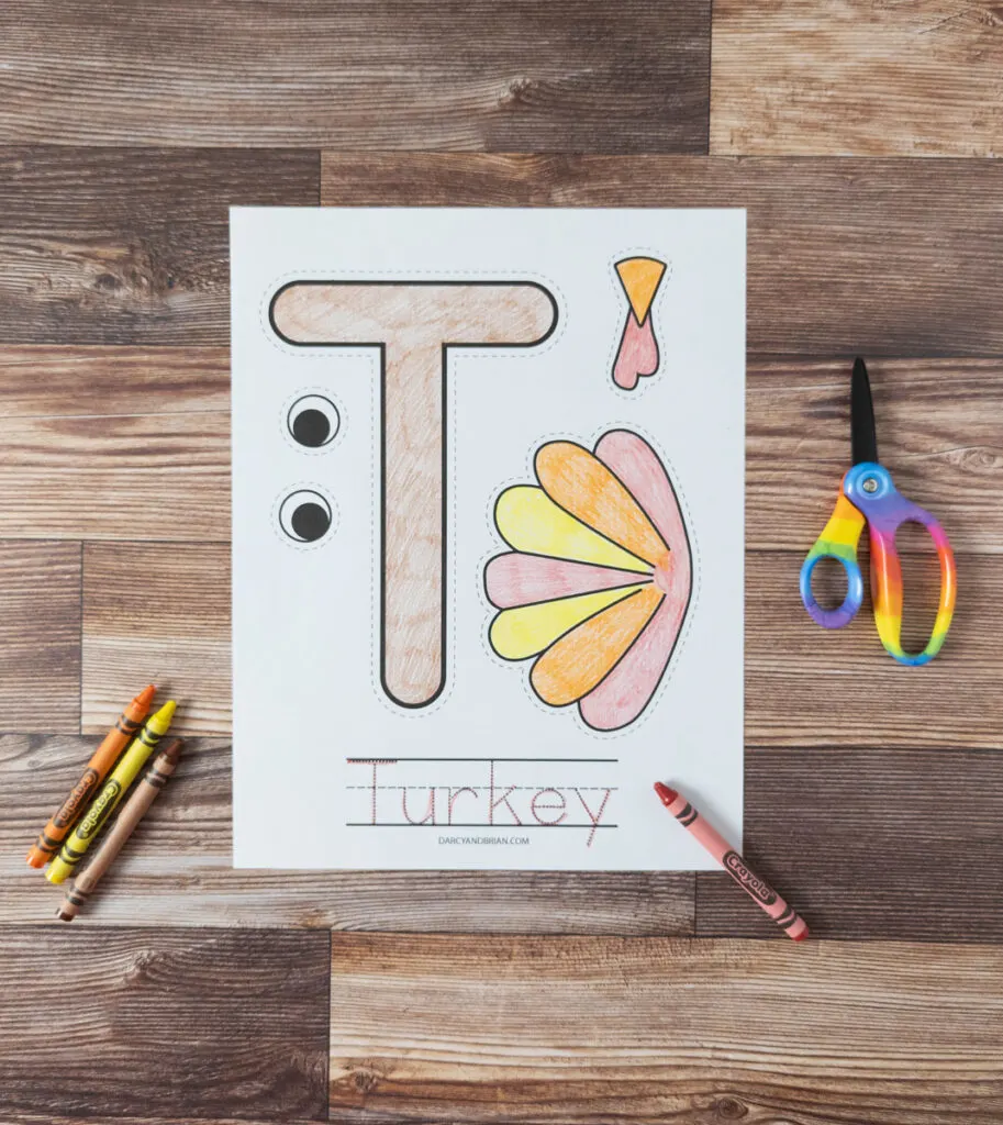 Pieces of T is for Turkey printable craft colored in with crayons. The word turkey has been traced with a red crayon.