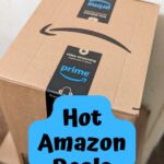 Close view of a medium sized Amazon box. Black text on a blue background near the bottom says Hot Amazon Deals.