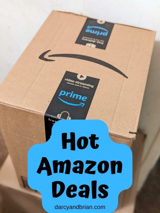 Close view of a medium sized Amazon box. Black text on a blue background near the bottom says Hot Amazon Deals.