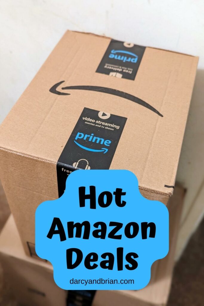 Close view of a medium sized Amazon box. Black text on a blue background near the bottom says Hot Amazon Deals.