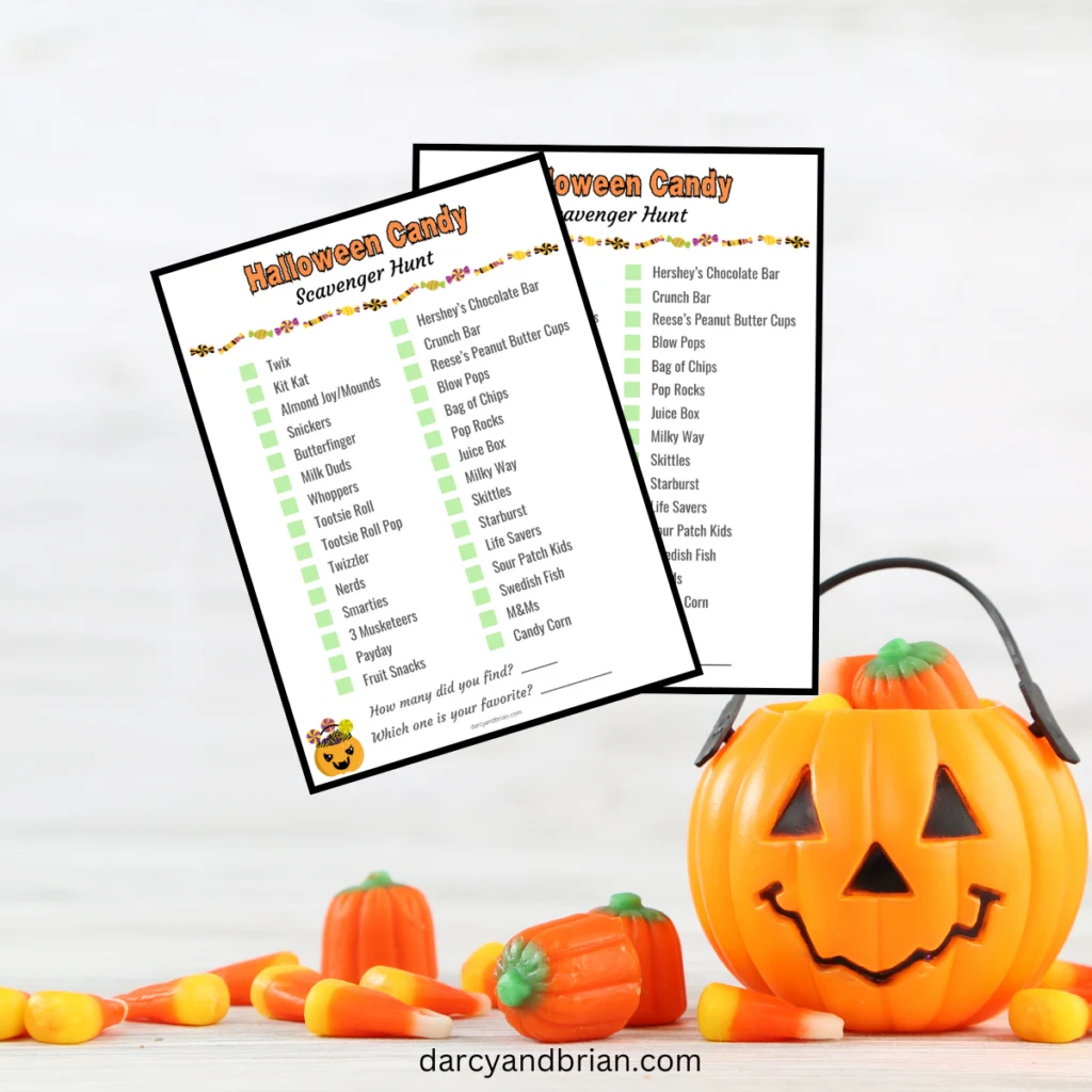 Mockup with two Halloween candy scavenger hunt checklists overlapping each other on a background with a small pumpkin bucket, candy corn, and candy pumpkins.