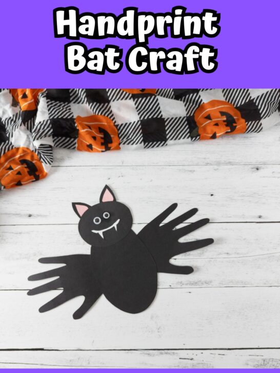 White text on purple background at top says Handprint Bat Craft. Photo of bat made out of black paper using handprints for wings.