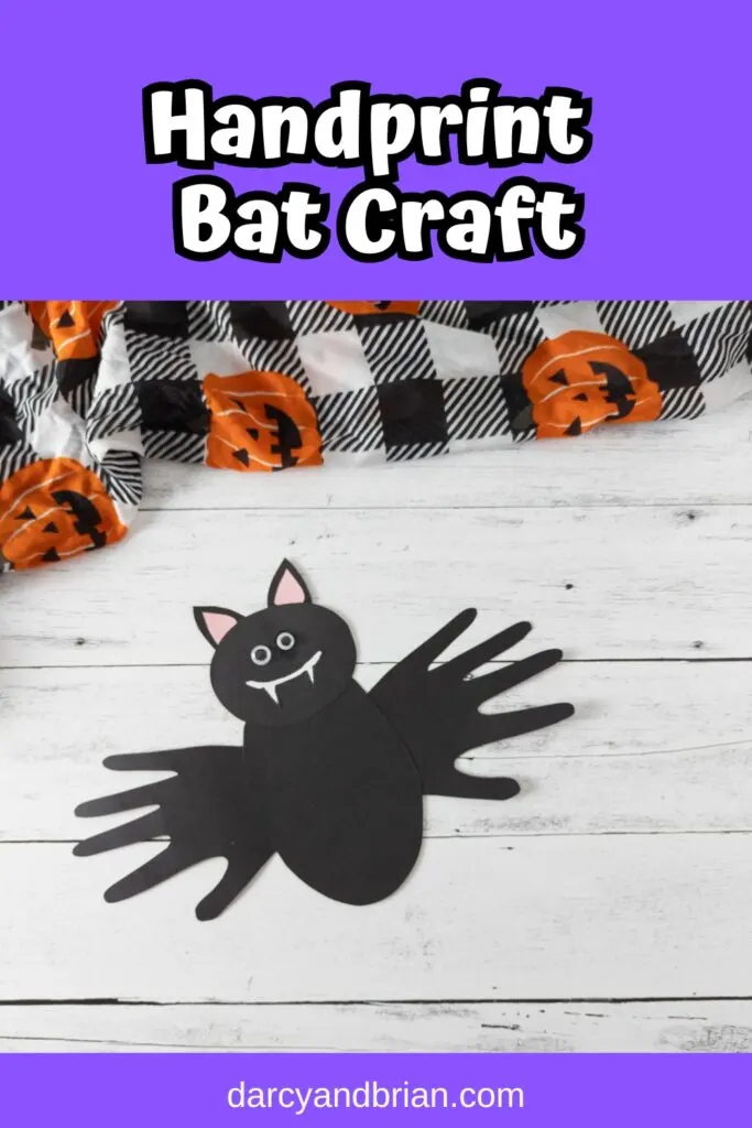 White text on purple background at top says Handprint Bat Craft. Photo of bat made out of black paper using handprints for wings.