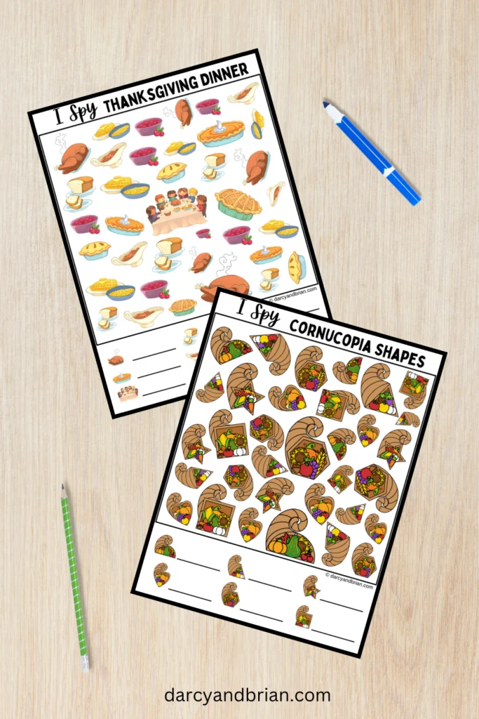 Mockup of the colorful I Spy Cornucopia Shapes and I Spy Thanksgiving Dinner pages on a desk background with pencil and marker laying nearby.