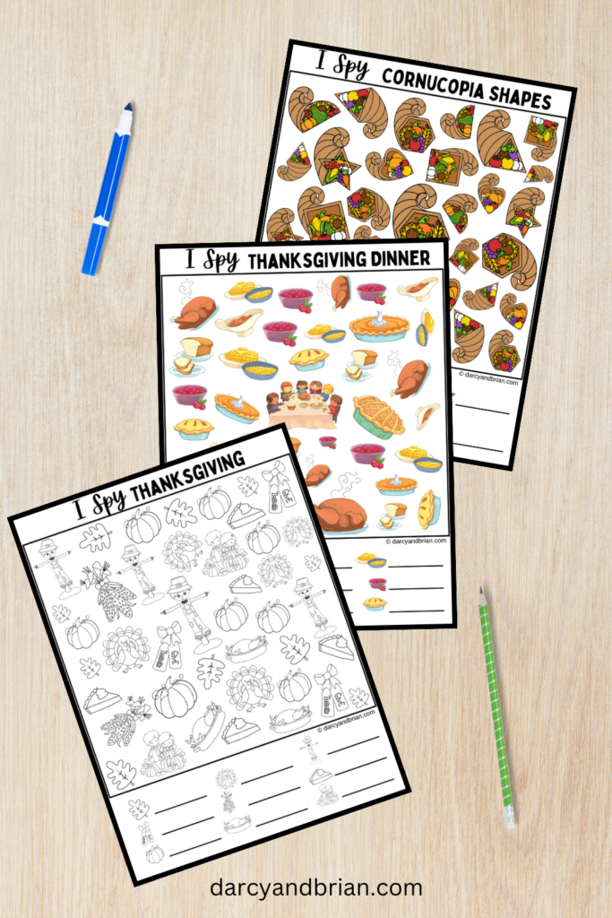 Mockup of three different Thanksgiving themed i spy worksheets fanned out on desk with marker and pencil.