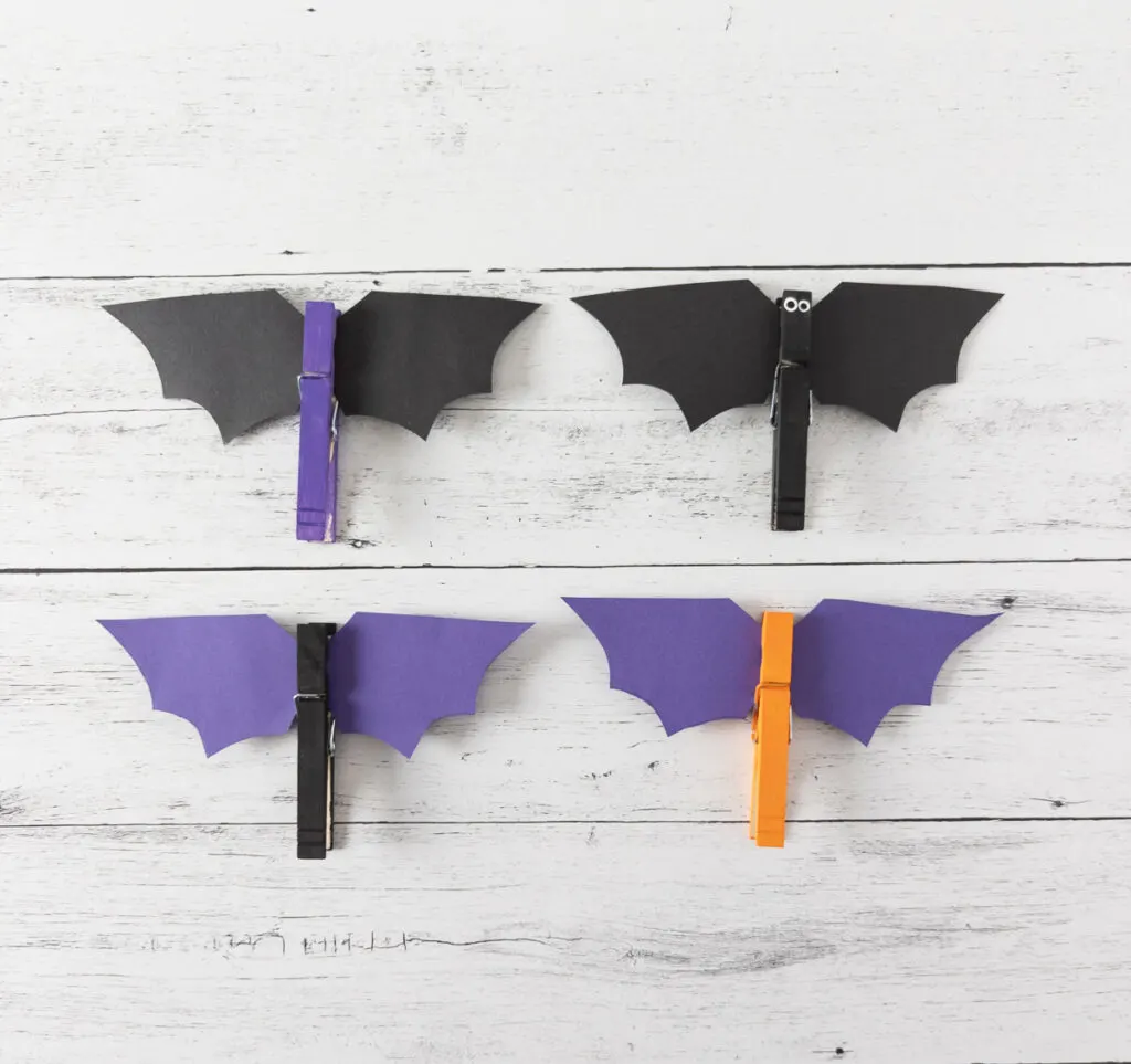 Four completed bats made with painted clothespins and paper wings.