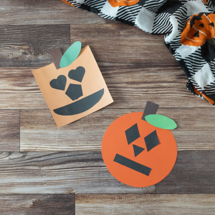 Completed shape pumpkin crafts on table (one circle and one square) next to black and white plaid fabric with jack-o-lanterns on it.