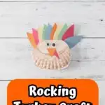 Completed turkey craft made with a folded paper plate and construction paper. White and black text on orange near the bottom says Rocking Turkey Craft.