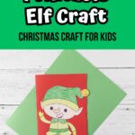 White text on green near the top says Printable Elf Craft. Black text says Christmas Craft for Kids. Photo of printable elf craft colored with crayons and glued onto red card stock to make a card.