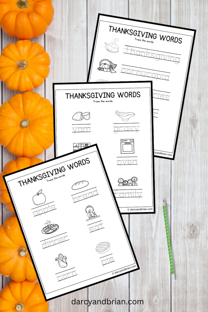 Digital mockup of three handwriting practice worksheets on a background with pumpkins. All three pages have Thanksgiving themed words to trace.