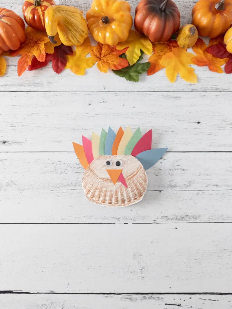 Finished easy rocking turkey craft made with paper plate and construction paper.