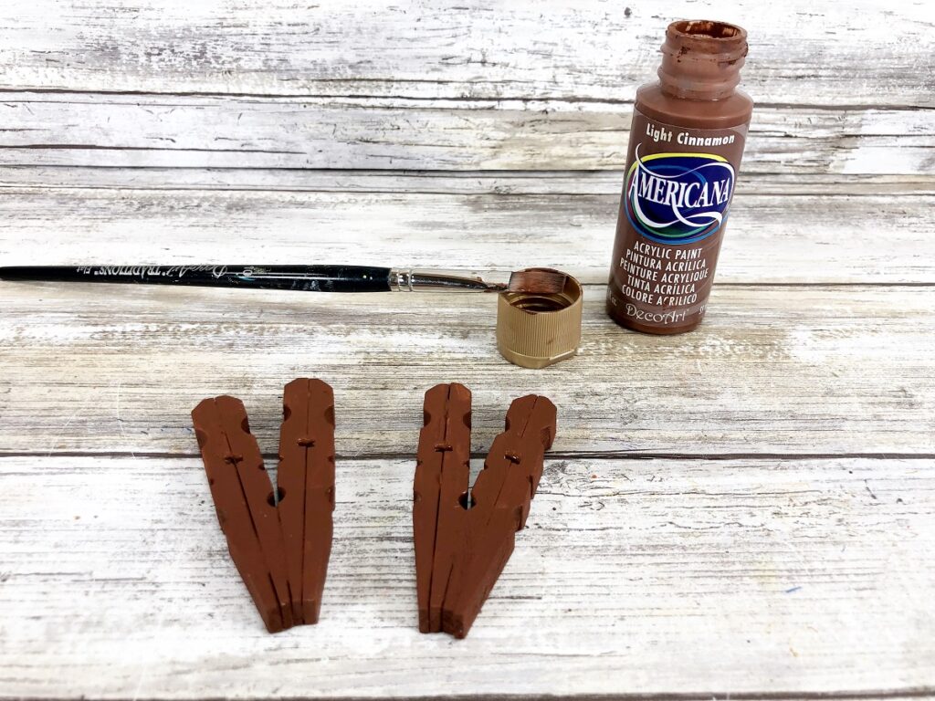 Painting reindeer clothespins brown.