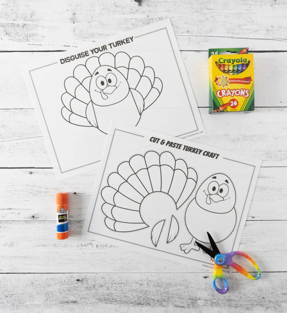 Printable turkey craft and disguise a turkey coloring pages printed out. Glue stick, scissors and box of crayons arranged around them.