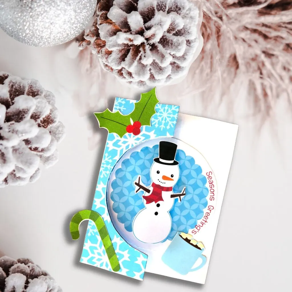 Finished snowman holiday card on a winter background.