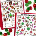 Mockup of the full color Christmas I Spy printable worksheets laying on red paper. Green and red circle confetti around the pages.