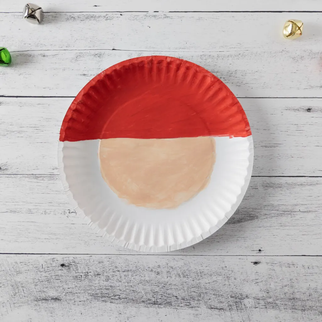 Paper plate with top portion painted red and center painted peach.