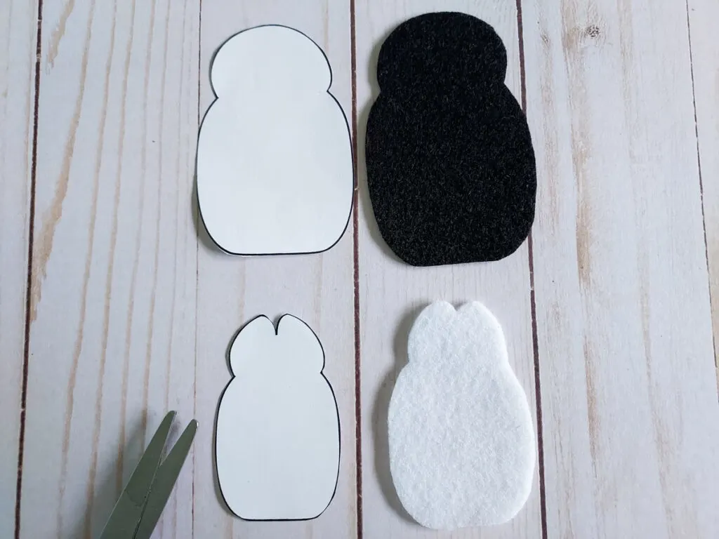 Penguin craft template pieces next to felt cut outs.