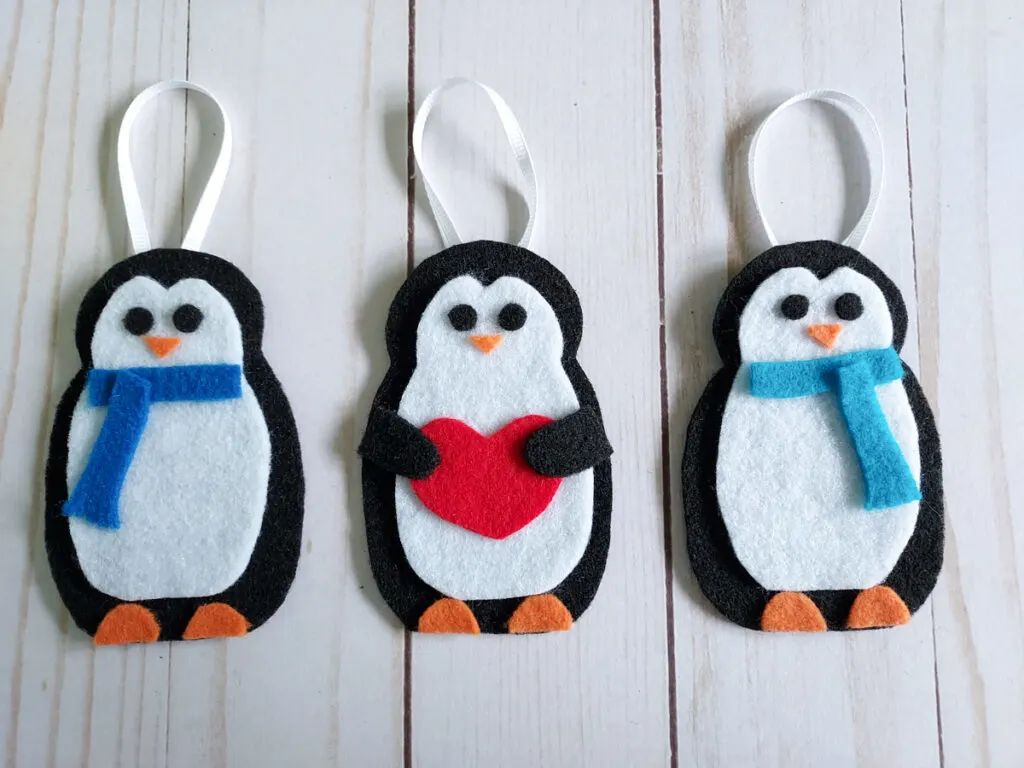 Completed felt penguin ornaments laying in a row.