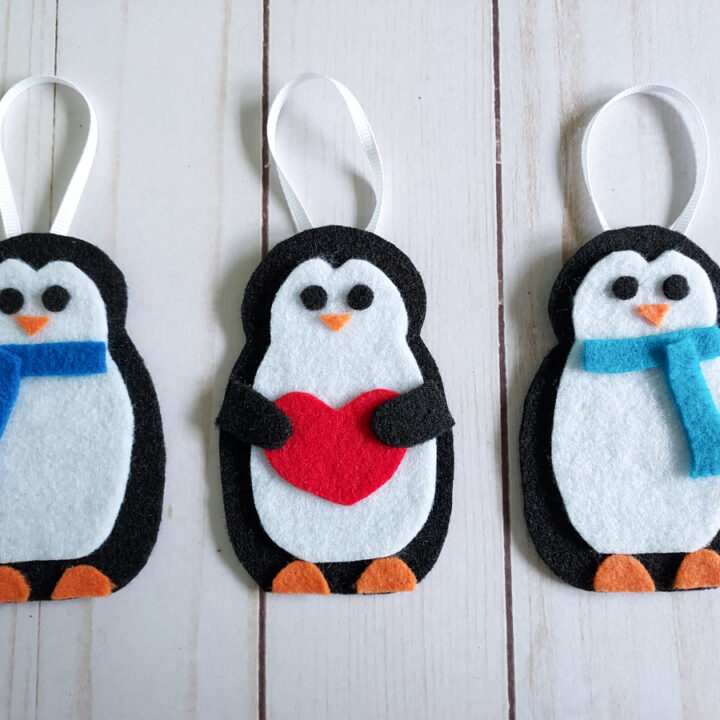 Completed felt penguin ornaments laying in a row.