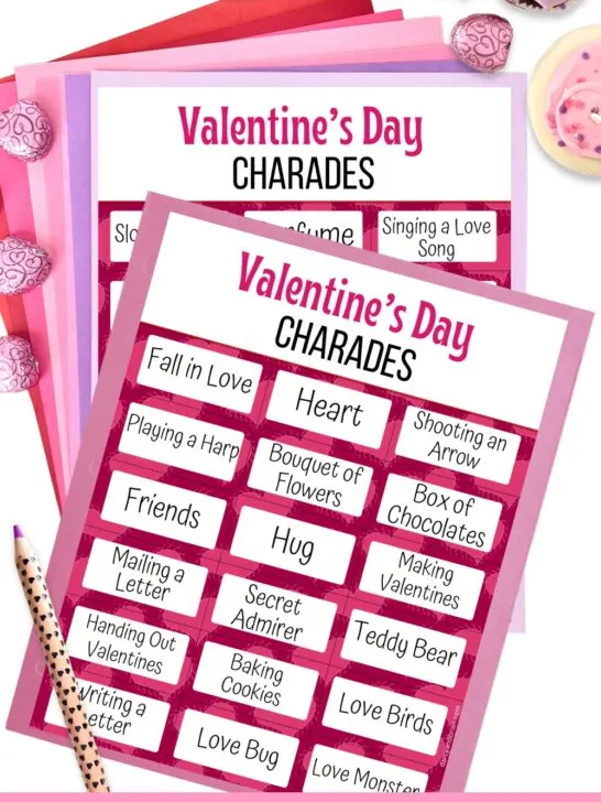 Mockup of Valentine's Day charades printable cards laying on pink and purple papers.