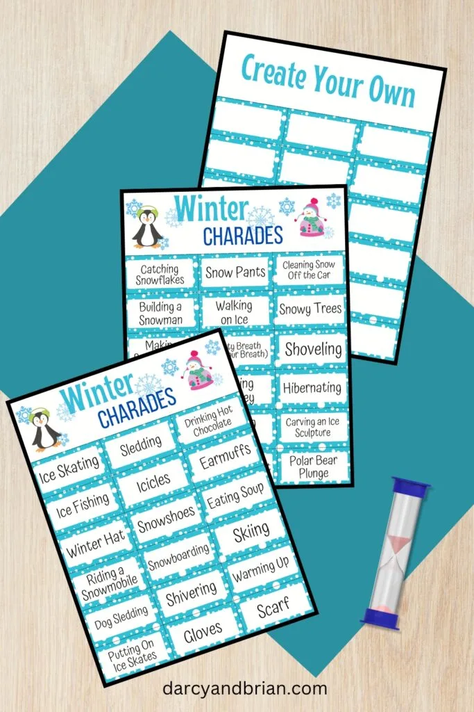 Mockup with two pages of winter acting prompts and one sheet of blank cards laying across a dark teal paper on a desk next to a sand timer.