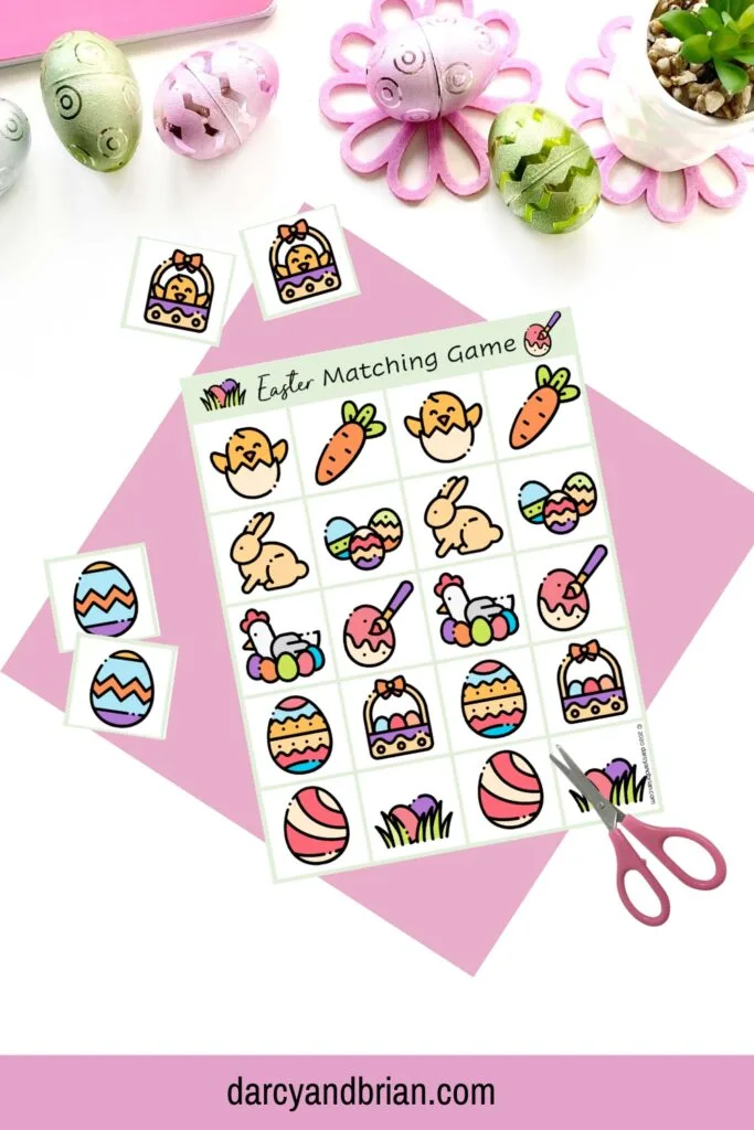 One page of Easter memory matching game on top of pink paper and a small pair of scissors. A couple matching cards around the sides.