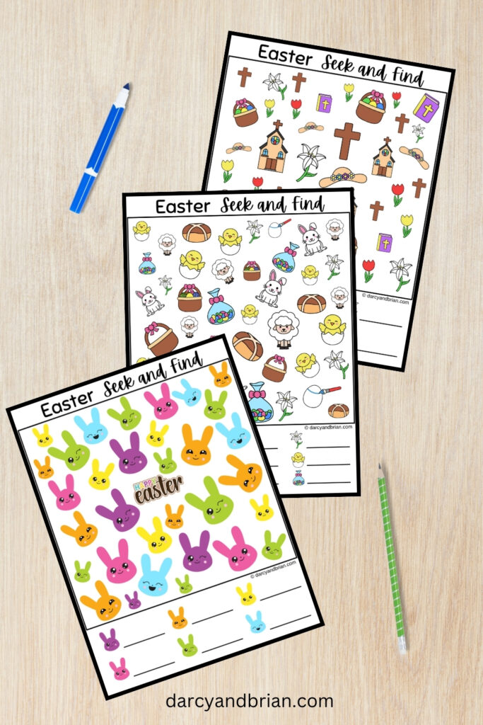 Three pages of Easter themed look and find printable pages fanned out over desk background. Marker and pencil lay next to pages.