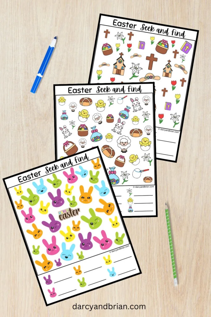 Three pages of Easter themed look and find printable pages fanned out over desk background. Marker and pencil lay next to pages.