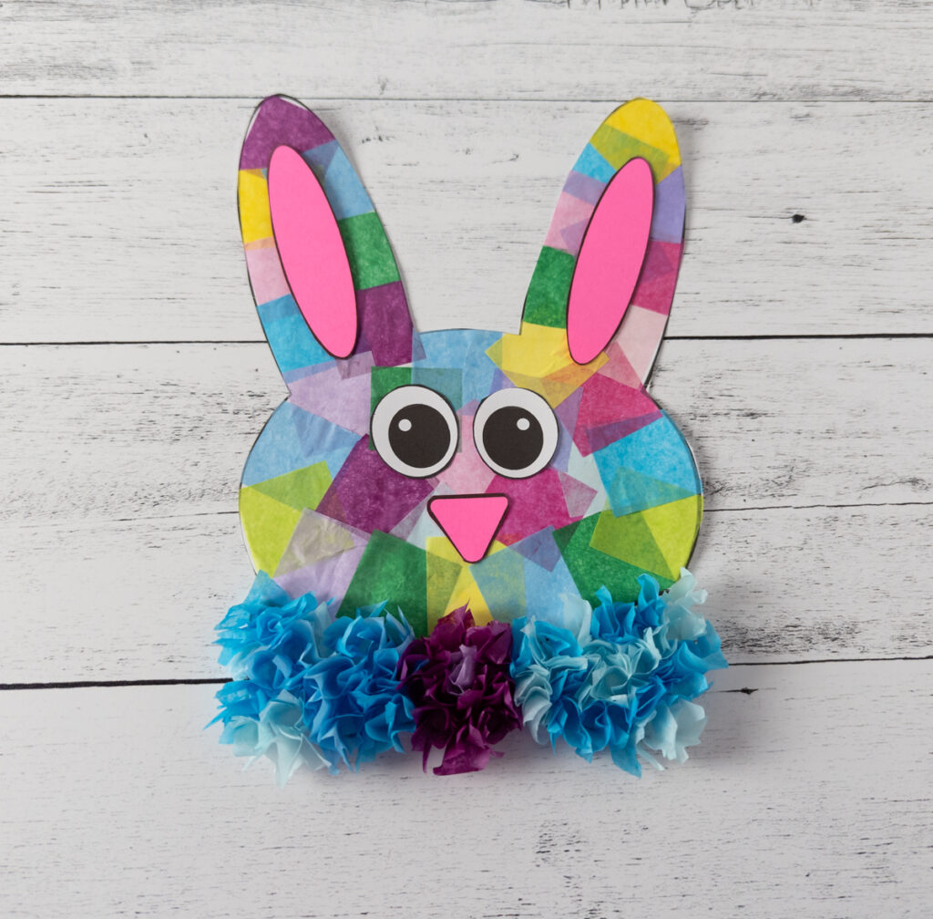 Multi-colored tissue paper Easter bunny head with facial features glued on.