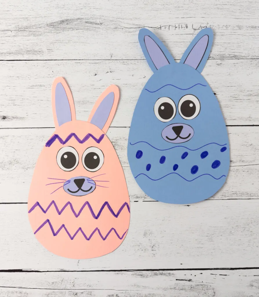 Pink and blue Easter egg shaped papers decorated to look like bunnies. The egg bodies have dots and stripes to look like Easter eggs.