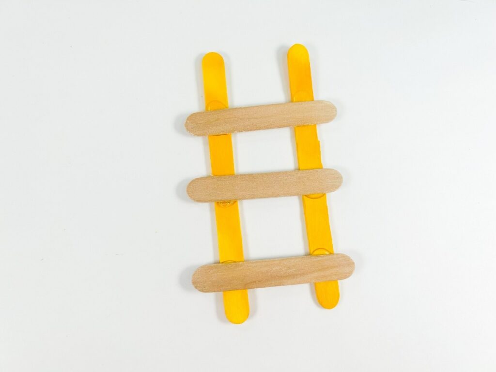 Small ladder made with two regular popsicle sticks and three mini popsicle sticks.