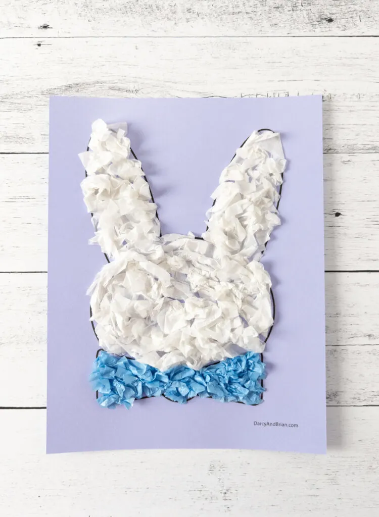 Easter bunny template printed out on lavender cardstock. White tissue paper covers bunny head and blue tissue paper in bowtie.