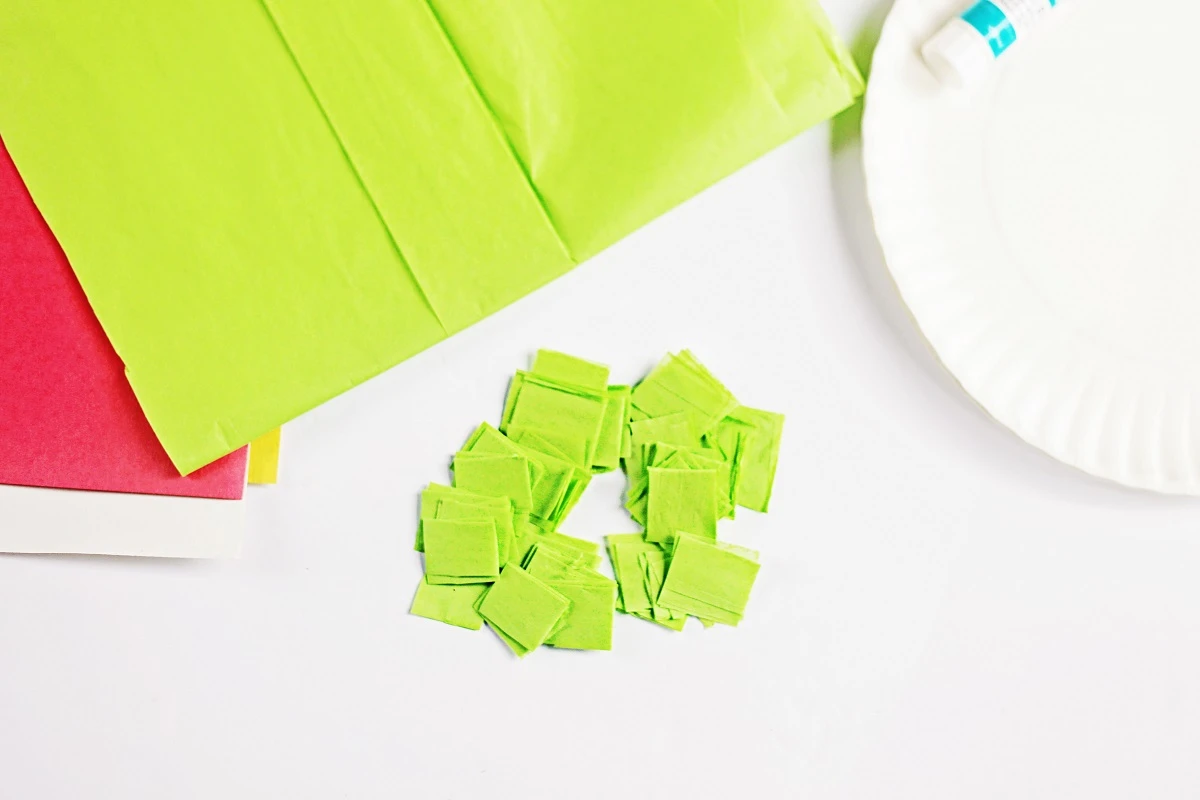 Pile of green tissue paper cut into squares.