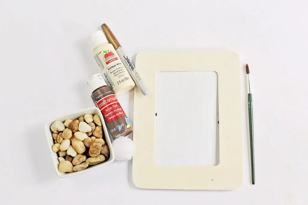 Supplies for My Dad Rocks craft includes a wooden frame, brown paint, white paint, a marker, and a box of rocks.